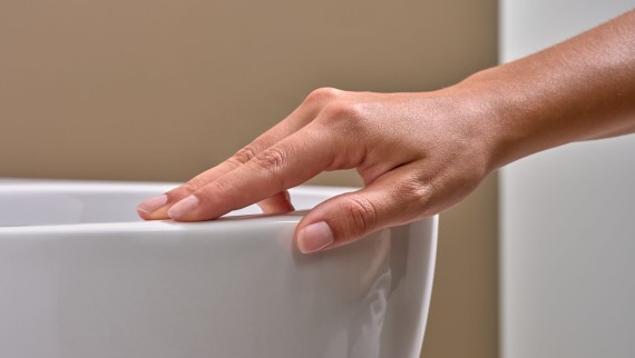 Hand streicht über WC mit Spezialglasur KeraTect® Hand streicht über WC mit Spezialglasur KeraTect®