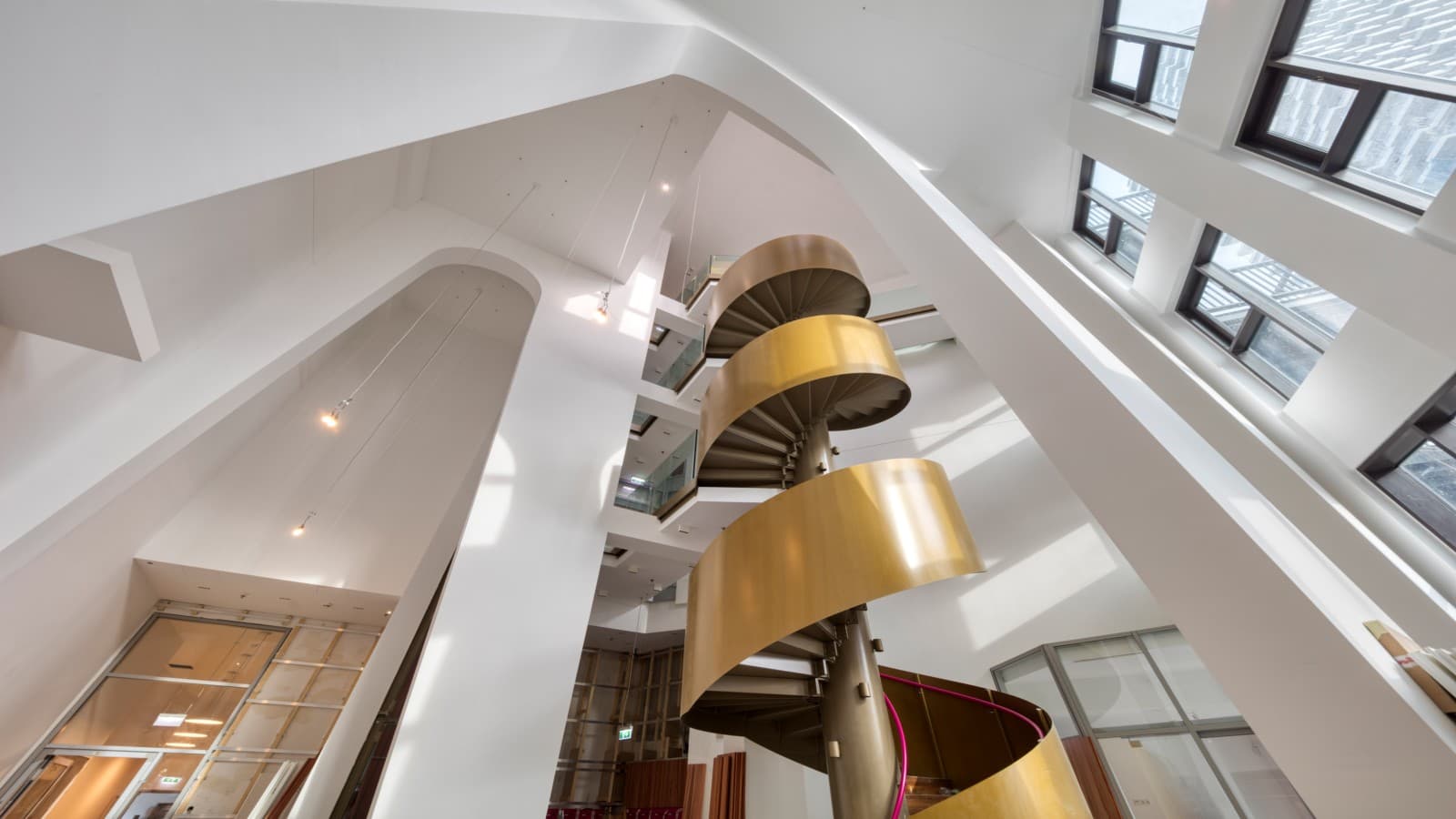 Stilvolles Entree – ca. 16 Meter Raumhöhe, schräge Säulen und eine goldene Wendeltreppe sind die effektvollen Gestaltungselemente, die Bewohner und Besucher bereits beim Eintreten erwarten. (c) Geberit/Stephan Huger Stilvolles Entree – ca. 16 Meter Raumhöhe, schräge Säulen und eine goldene Wendeltreppe sind die effektvollen Gestaltungselemente, die Bewohner und Besucher bereits beim Eintreten erwarten. (c) Geberit/Stephan Huger